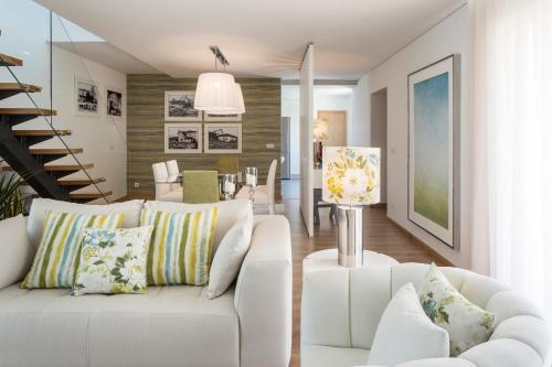a living room with a white couch and a staircase at Gallo`s House in Barcelos