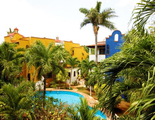 un complejo con piscina y palmeras en Maya Vacanze Playa Alegria en Playa del Carmen