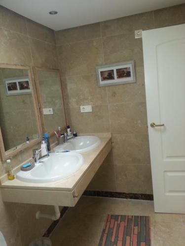 a bathroom with two sinks and a mirror at Duquesa village El Hacho in Manilva