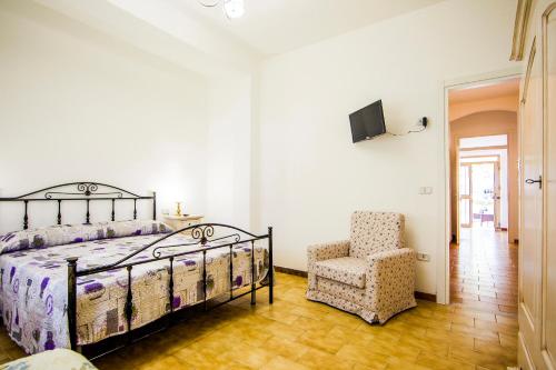 a bedroom with a bed and a chair at La Via Del Mare in Palinuro