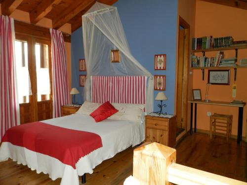 a bedroom with a white bed with a red blanket at Casa rural Estrella Polar II in Arcones