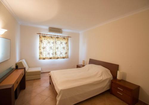 ヴァーレ・ド・ローボにあるCasa das Floresのベッドルーム(ベッド1台、窓付)
