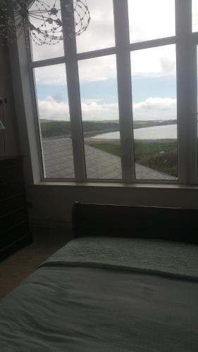 a bedroom with a large window looking out at the water at Wild Atlantic Lodge Bed & Breakfast in Lahinch