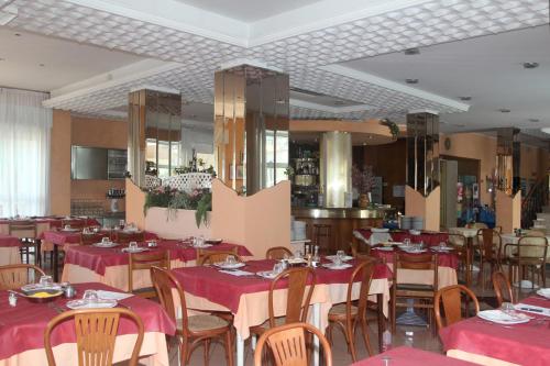 a restaurant with tables and chairs with red tablecloths at Hotel Bellavista-Olympic in Bellaria-Igea Marina