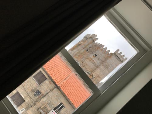 a view of a castle through a window at Hotel Medieval® de Penedono in Penedono