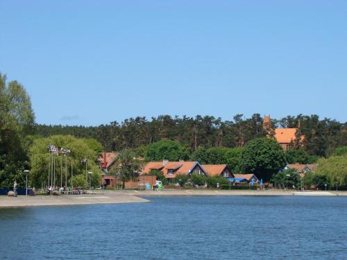a body of water with houses in the background at Apartamentai Dorė in Nida