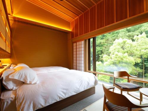 a bedroom with a bed and a large window at Asan Kotonami in Manno