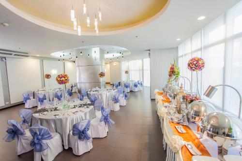 a banquet hall with white tables with blue bows at The Exchange Regency Residence Hotel Managed by HII in Manila