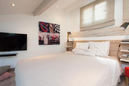 a bedroom with a white bed and a flat screen tv at Superbe appartement loft vieil Antibes in Antibes