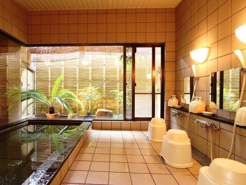 een badkamer met 2 toiletten en een aquarium bij Marumo Ryokan in Takashima