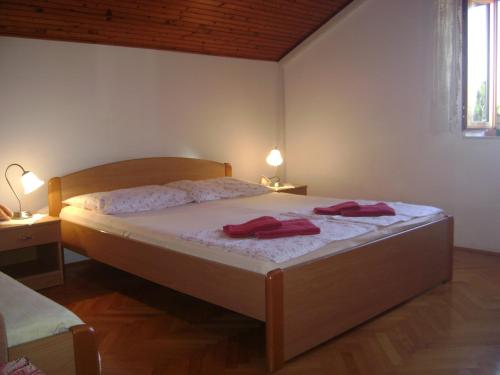a bedroom with a bed with two red towels on it at Apartment ANDRIUCI in Cavtat