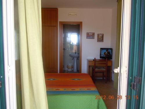 a room with a bedroom with a bed and a desk at Pensione San Michele in Mattinata