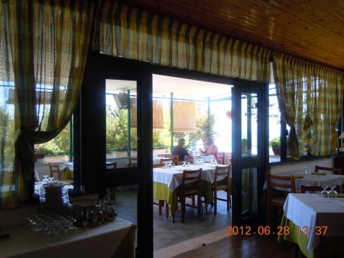 a restaurant with tables and a person sitting at a table at Pensione San Michele in Mattinata