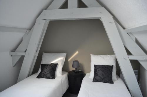 two twin beds in a room with white walls at Maison Coetquen in Saint Malo