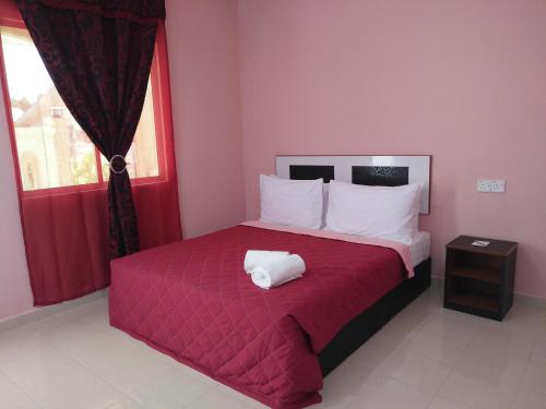 ein Schlafzimmer mit einem großen Bett mit einer roten Decke in der Unterkunft Sri Melor Inn in Pantai Cenang