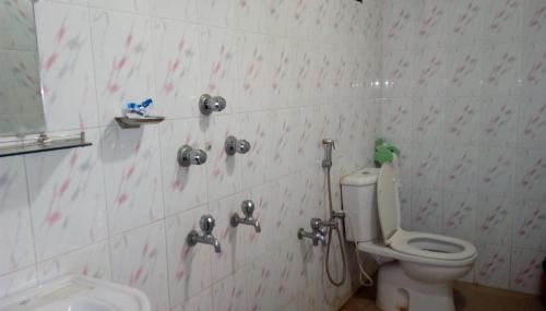 a bathroom with a toilet with red hearts on the wall at Hotel Plaza in Bāndarban