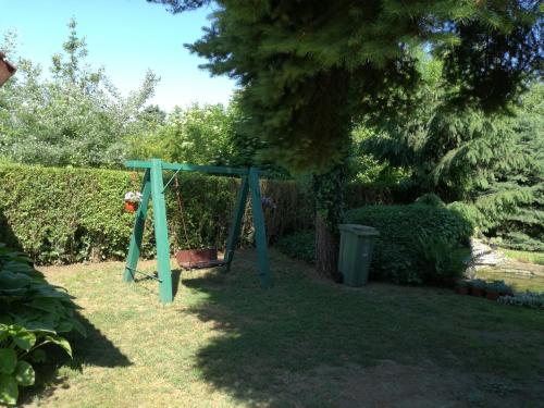 a swing in a yard with a tree at Stara Breza 1 Rooms in Palić