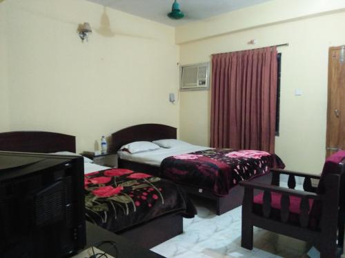 a hotel room with two beds and a television at Hotel Plaza in Bāndarban