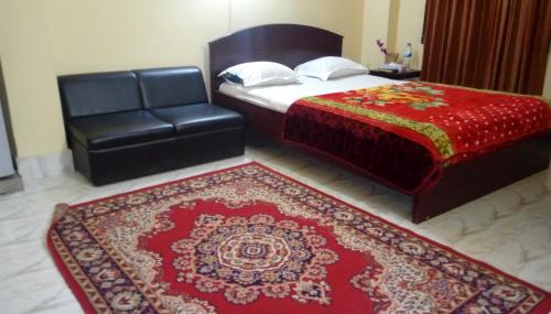 a bedroom with a bed and a chair and a rug at Hotel Plaza in Bāndarban