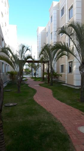 a walkway with palm trees in front of a building at Condominio Mar de Gales in Macaé