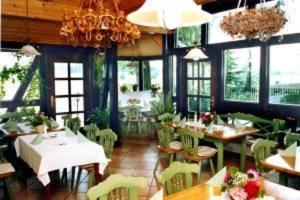 una sala da pranzo con tavoli, sedie e finestre di Hotel Gasthof zur Linde a Weißbach