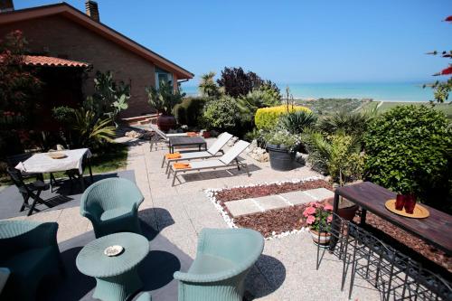 eine Terrasse mit Stühlen, Tischen und einem Tisch in der Unterkunft B&B La Casa di Era in Porto San Giorgio