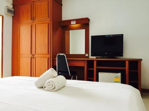 Una habitación de hotel con una cama con toallas. en Panchan Place en Ubon Ratchathani