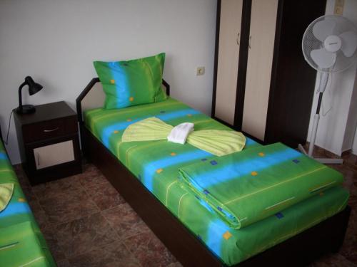 ポモリエにあるGeorgievi Guest Houseのベッドルーム1室(緑のシーツと枕付きのベッド1台付)