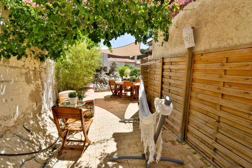 a patio with a fence and a table and chairs at Les Chambres d'Hôtes du Grand Mornas in Carry-le-Rouet