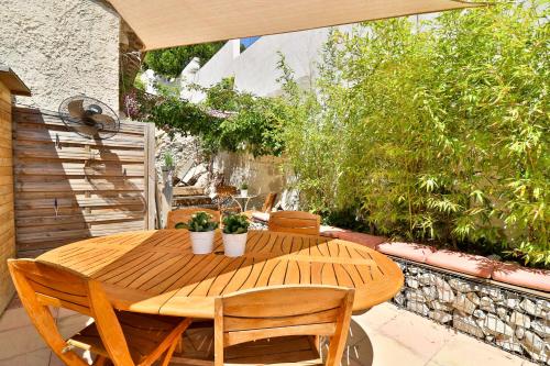 a wooden table and chairs on a patio at Les Chambres d'Hôtes du Grand Mornas in Carry-le-Rouet