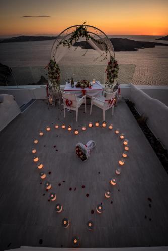 a heart made out of lights on a table with a sunset at Fira Deep Blue Suites in Fira