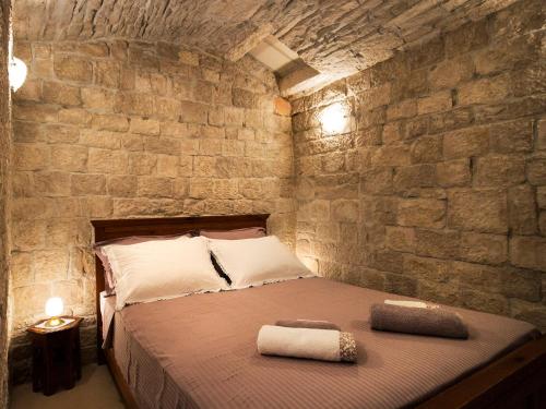 a bedroom with a bed in a brick wall at Apartment Lejla in Povlja