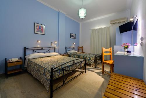 a hotel room with two beds and a television at Akis Hotel in Kamari