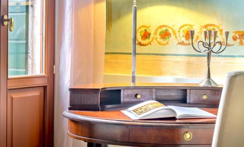 a wooden table with a book and a sword at Hotel Palazzo Vitturi in Venice