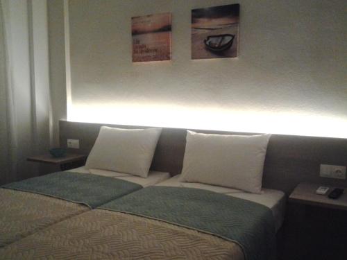 a bedroom with a bed with a light above it at Lola's Hotel in Plataniás