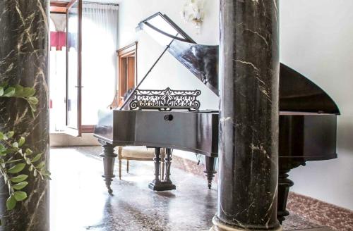 a black piano in a room with a mirror at Hotel Palazzo Vitturi in Venice