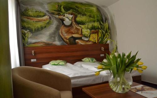 フリンブルクにあるLipno-Apartmán Frymburk D110のベッドルーム1室(テーブル付きのベッドの上に絵画付)