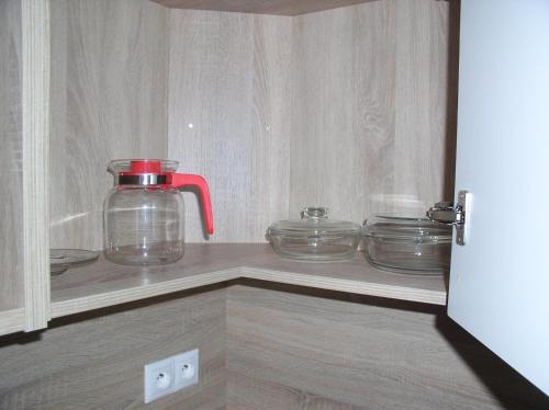 a kitchen cabinet with a glass jug and dishes on a shelf at Apartmán Cyril A 104 in Smokovce
