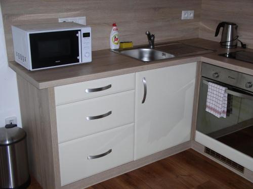 a kitchen with a microwave and a sink at Apartmán Cyril A 104 in Smokovce