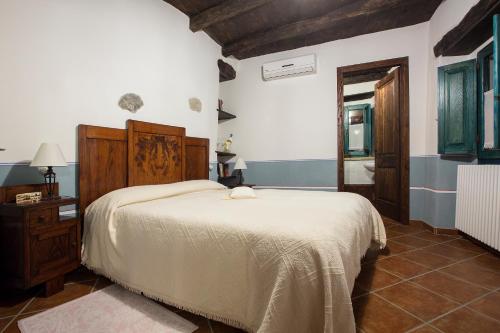 a bedroom with a large bed with a wooden headboard at B&B Charme Sa Pardina in Orroli