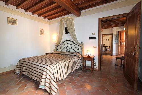 a bedroom with a large bed with a striped blanket at Agriturismo Badia Ficarolo in Palazzo del Pero