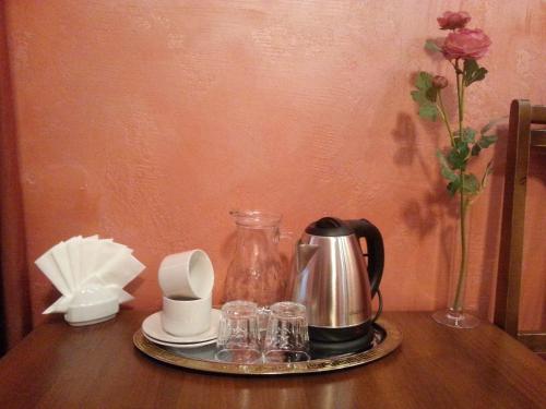 a tray with a coffee pot and glasses on a table at Guest House na Slobodskoy in Saint Petersburg