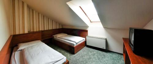 a small bedroom with two beds and a window at Europa Hotel És Étterem in Nyíregyháza