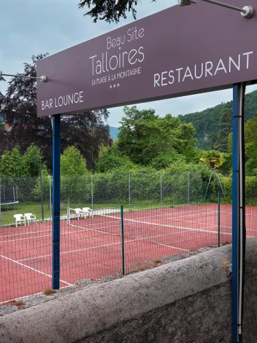 a sign on a tennis court with a tennis court at Hôtel Beau Site Talloires B SPA in Talloires