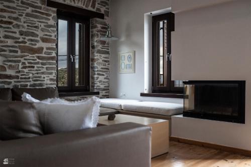 a living room with a couch and a fireplace at Stone Villa Pelion in Afissos