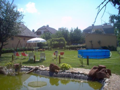 un patio trasero con un estanque y una zona de juegos en Haus Liberty en Balatonlelle