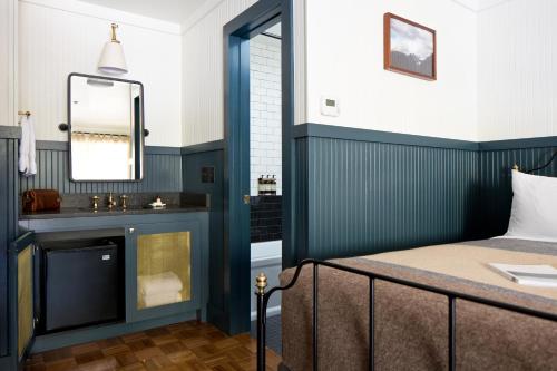 a bedroom with a bed with a mirror and a sink at Anvil Hotel in Jackson