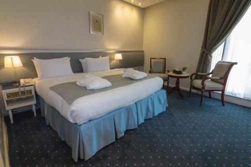 a hotel room with a large bed with two towels at Montana Al Azizia Hotel in Makkah