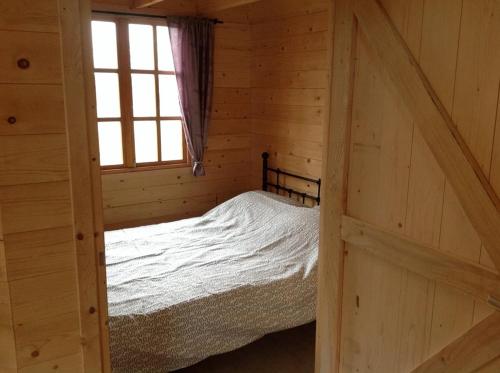 een slaapkamer met een bed in een blokhut bij Hollands Oostenrijks huisje in Wieringerwerf