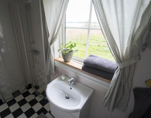 a bathroom with a toilet and a sink and a window at Anfasteröd Gårdsvik - Sjöstugan in Ljungskile